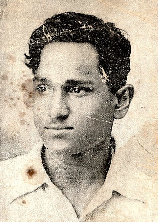 A worn and stained photograph of a young Batukeshwar Dutt, reproduced from a 1930 Lahore Conspiracy Case poster.